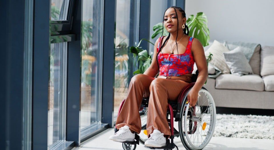 Teenage female, sitting in a wheelchair looking at the camera with a proud look on her face.